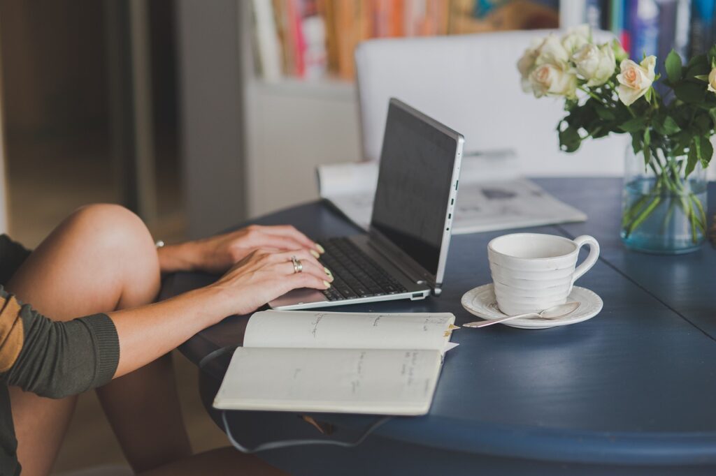 Frau beim Schreiben am Laptop: 9 Tipps, die den Schreibstil verbessern
